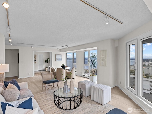 121 Vine St Unit 2405, Seattle, WA 98121 - living area featuring rail lighting, a textured ceiling, and light wood finished floors