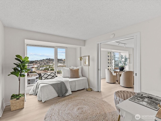 121 Vine St Unit 2405, Seattle, WA 98121 - bedroom with light wood-style floors and a textured ceiling