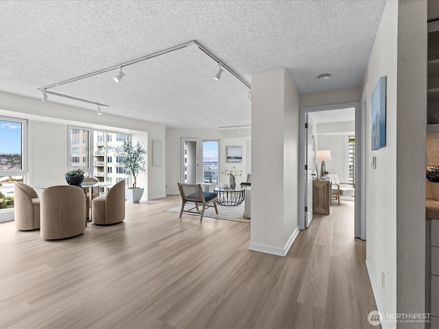 121 Vine St Unit 2405, Seattle, WA 98121 - living room with rail lighting, wood finished floors, a textured ceiling, and plenty of natural light
