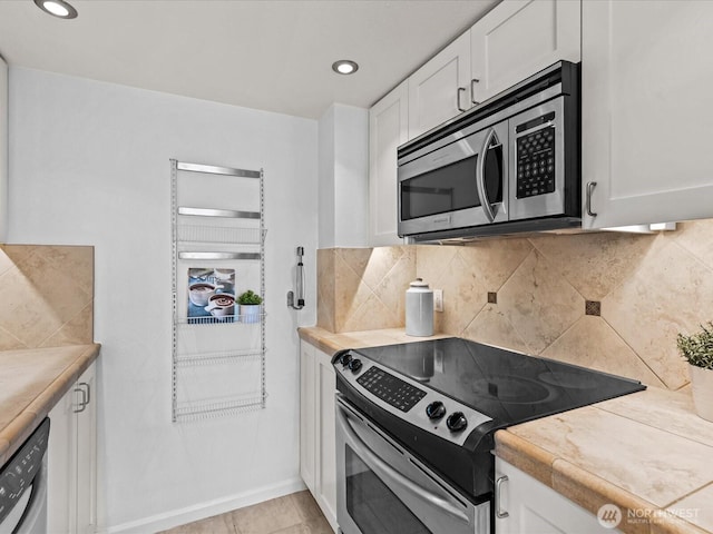 121 Vine St Unit 2405, Seattle, WA 98121 - kitchen with stainless steel appliances, white cabinetry, light countertops, tasteful backsplash, and recessed lighting