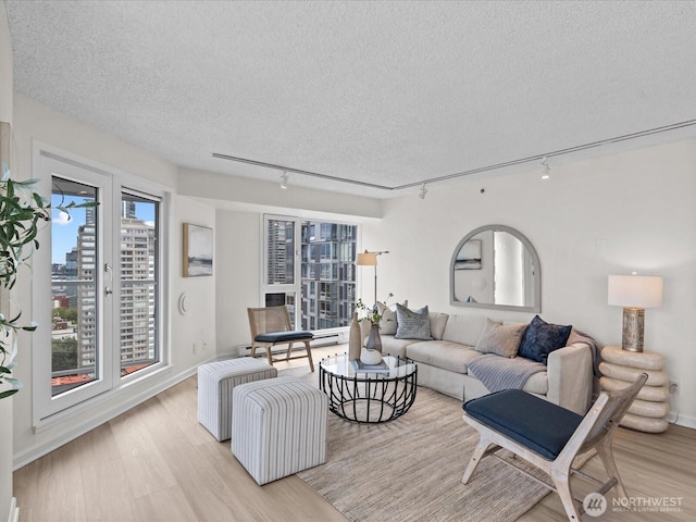 121 Vine St Unit 2405, Seattle, WA 98121 - living room with rail lighting, light wood finished floors, and a textured ceiling