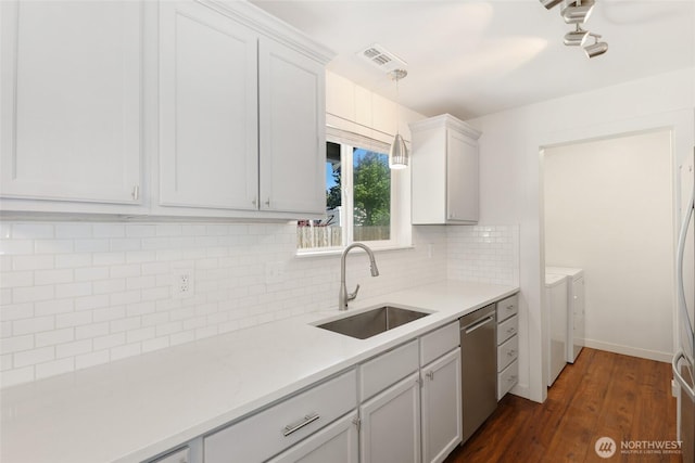 11950 SE 253rd St, Kent, WA 98030 - kitchen with washing machine and clothes dryer, stainless steel dishwasher, light countertops, tasteful backsplash, and dark wood-style flooring