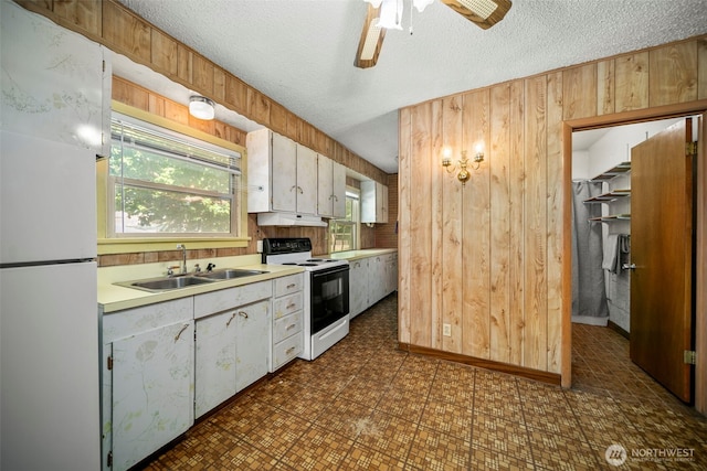 2301 NW Cascade Ave, East Wenatchee, WA 98802 - kitchen with white appliances, wood walls, light countertops, a textured ceiling, and ceiling fan