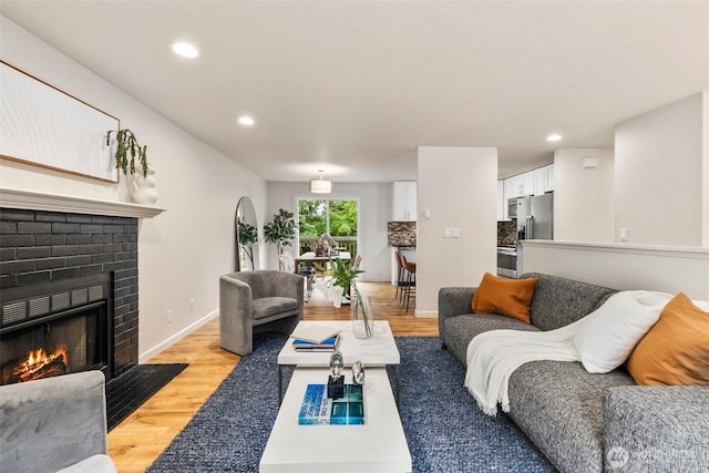 4133 23rd Ave SW, Seattle, WA 98106 - living area with light wood-type flooring, a brick fireplace, and recessed lighting