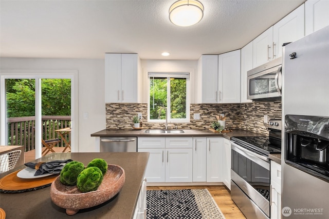 4133 23rd Ave SW, Seattle, WA 98106 - kitchen featuring stainless steel appliances, dark countertops, and plenty of natural light