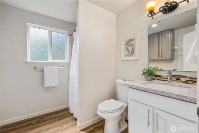 4133 23rd Ave SW, Seattle, WA 98106 - full bathroom featuring vanity, wood finished floors, backsplash, and a shower with shower curtain