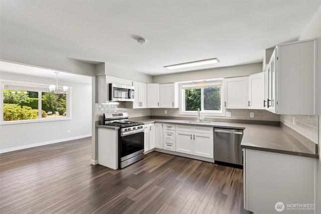 1524 26th Ave NE, Olympia, WA 98506 - kitchen featuring appliances with stainless steel finishes, backsplash, dark wood finished floors, white cabinetry, and dark countertops