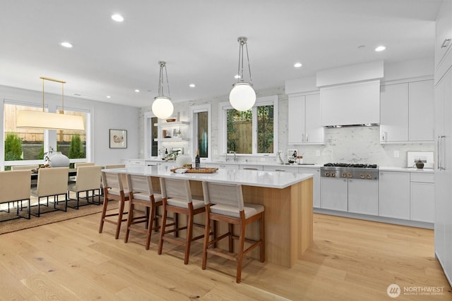 233 19th Ave, Kirkland, WA 98033 - kitchen with stainless steel gas cooktop, a kitchen island, light countertops, white cabinetry, and light wood-style flooring