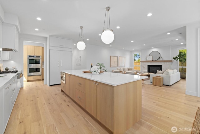 233 19th Ave, Kirkland, WA 98033 - kitchen featuring modern cabinets, a large island, stainless steel double oven, recessed lighting, and light wood finished floors