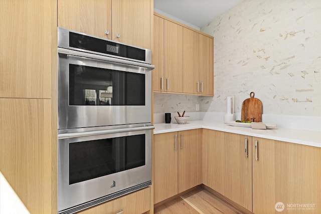 233 19th Ave, Kirkland, WA 98033 - kitchen featuring stainless steel double oven, light brown cabinetry, light countertops, and light wood finished floors