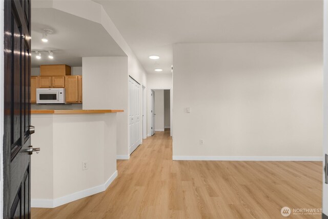 6409 Hazel Ln SE Unit H, Auburn, WA 98092 - kitchen with white microwave, light wood-style flooring, and light countertops
