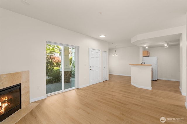 6409 Hazel Ln SE Unit H, Auburn, WA 98092 - unfurnished living room featuring light wood finished floors, a high end fireplace, and recessed lighting