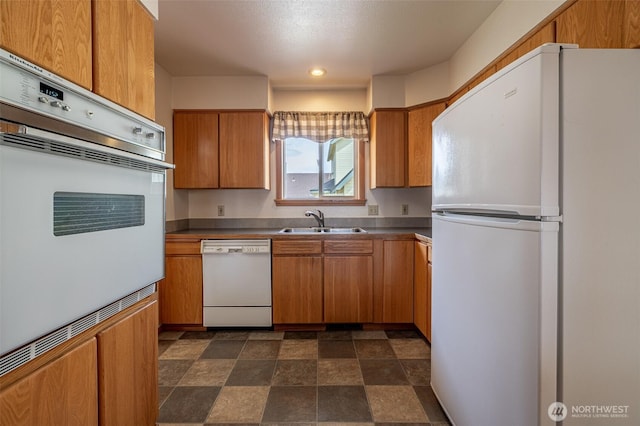 1312 Welch Ave, Wenatchee, WA 98801 - kitchen featuring white appliances, stone finish floors, brown cabinetry, dark countertops, and recessed lighting