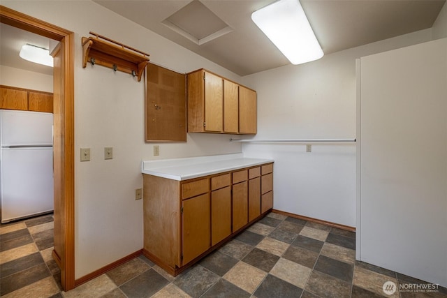 1312 Welch Ave, Wenatchee, WA 98801 - kitchen with freestanding refrigerator, light countertops, brown cabinets, and stone finish floors