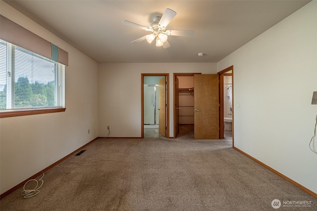1312 Welch Ave, Wenatchee, WA 98801 - unfurnished bedroom featuring light colored carpet, a spacious closet, connected bathroom, and ceiling fan