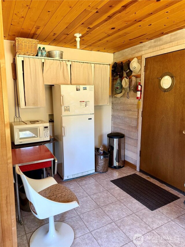 108 N Airport Way, Friday Harbor, WA 98250 - kitchen with white appliances, wood ceiling, light brown cabinetry, wooden walls, and light tile patterned floors