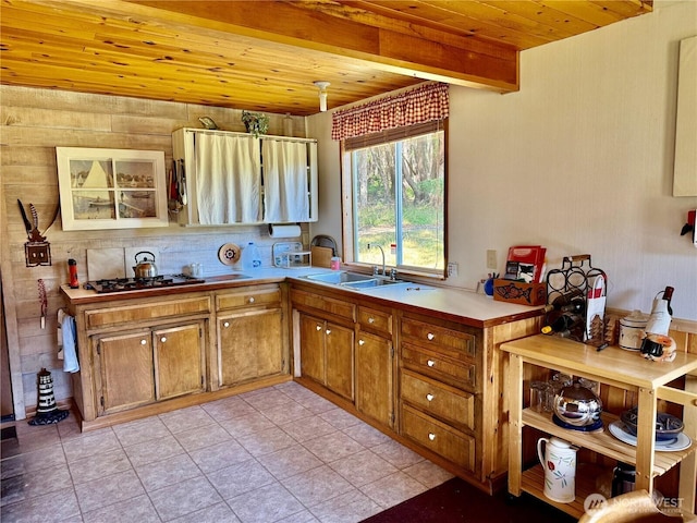 108 N Airport Way, Friday Harbor, WA 98250 - kitchen featuring a wooden ceiling with exposed beams, stainless steel gas cooktop, brown cabinetry, light tile patterned floors, and light countertops