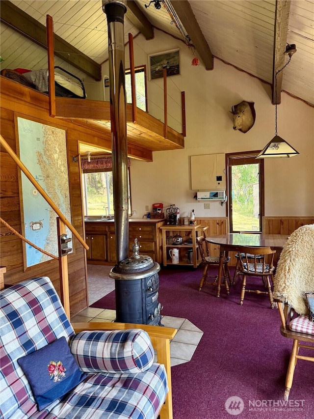 108 N Airport Way, Friday Harbor, WA 98250 - carpeted living area featuring wood walls, a wood stove, healthy amount of natural light, wood ceiling, and wainscoting