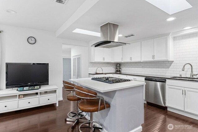 1501 58th Ave NE, Tacoma, WA 98422 - kitchen featuring stainless steel appliances, island range hood, a skylight, a kitchen breakfast bar, and backsplash