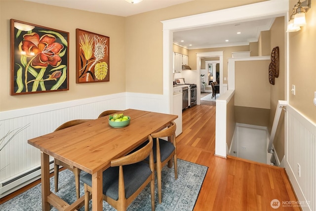 4010 Interlake Ave N, Seattle, WA 98103 - dining area featuring a baseboard heating unit, a wainscoted wall, light wood finished floors, ornamental molding, and recessed lighting