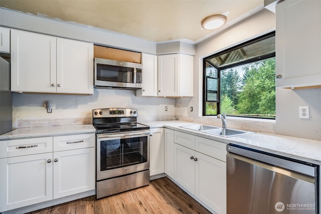 31107 11th Pl SW, Federal Way, WA 98023 - kitchen featuring stainless steel appliances, white cabinetry, light wood-style floors, and light stone counters