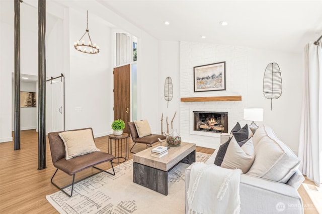 6401 146th Ave NE, Redmond, WA 98052 - living area with light wood-type flooring, lofted ceiling, a chandelier, a fireplace, and recessed lighting