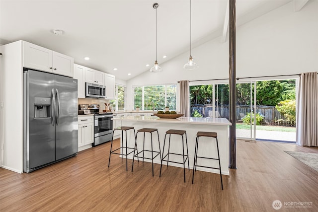 6401 146th Ave NE, Redmond, WA 98052 - kitchen featuring stainless steel appliances, light wood-style floors, a kitchen breakfast bar, white cabinets, and recessed lighting