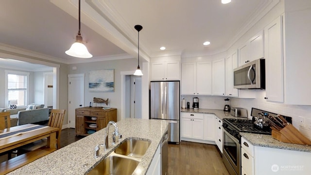 100 Horseshoe Ln, Pacific Beach, WA 98571 - kitchen with stainless steel appliances, crown molding, dark wood-style flooring, white cabinetry, and hanging light fixtures
