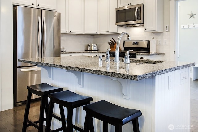 100 Horseshoe Ln, Pacific Beach, WA 98571 - kitchen with stainless steel appliances, tasteful backsplash, dark wood finished floors, and white cabinets