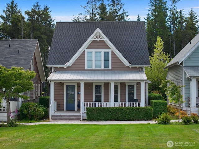 100 Horseshoe Ln, Pacific Beach, WA 98571 - view of front facade with covered porch, a front lawn, a standing seam roof, and a metal roof