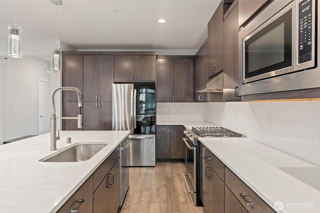 26637 NE Boyd Way Unit 102, Duvall, WA 98019 - kitchen with appliances with stainless steel finishes, light countertops, dark brown cabinets, under cabinet range hood, and recessed lighting