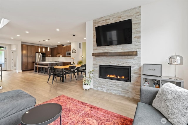26637 NE Boyd Way Unit 102, Duvall, WA 98019 - living room with light wood-style flooring, a stone fireplace, and recessed lighting