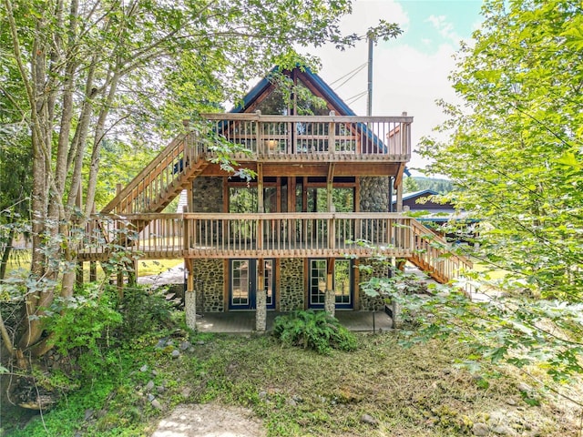 71 Waggler Way, Sequim, WA 98382 - back of property featuring stairs, a wooden deck, stone siding, and a patio area