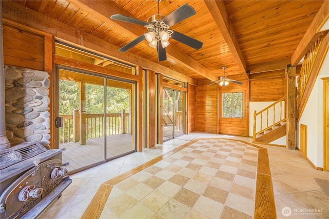 71 Waggler Way, Sequim, WA 98382 - doorway featuring a wooden ceiling with exposed beams, a wood stove, light tile patterned floors, a ceiling fan, and wood walls