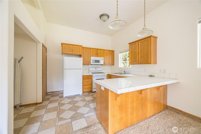 71 Waggler Way, Sequim, WA 98382 - kitchen featuring white appliances, a peninsula, a kitchen breakfast bar, brown cabinets, and decorative light fixtures