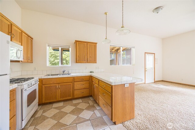 71 Waggler Way, Sequim, WA 98382 - kitchen with white appliances, a peninsula, tile counters, decorative light fixtures, and brown cabinetry