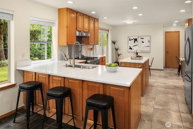 12820 SE 243rd St, Kent, WA 98030 - kitchen featuring under cabinet range hood, recessed lighting, a peninsula, a center island, and light countertops