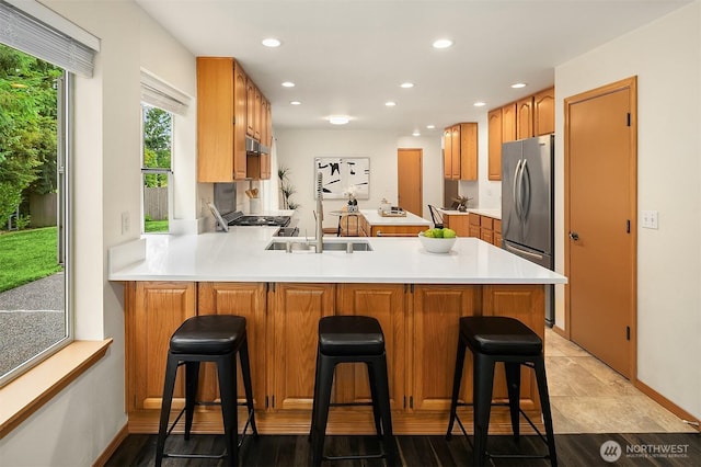 12820 SE 243rd St, Kent, WA 98030 - kitchen with freestanding refrigerator, a peninsula, light countertops, recessed lighting, and a kitchen bar