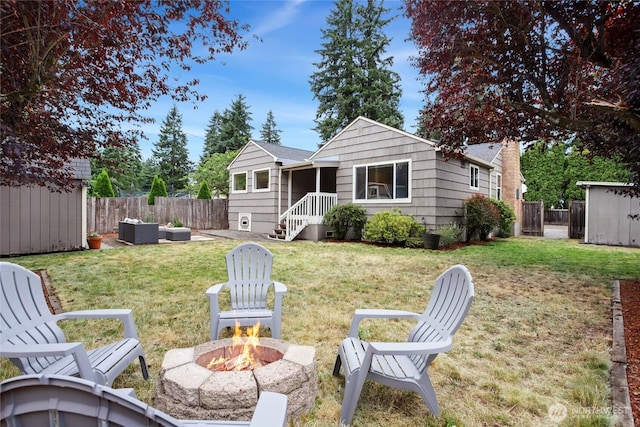 1339 N 167th St, Shoreline, WA 98133 - rear view of property featuring an outdoor fire pit, a storage shed, and a fenced backyard