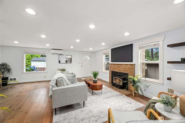 1339 N 167th St, Shoreline, WA 98133 - living area with an AC wall unit, wood finished floors, plenty of natural light, recessed lighting, and a fireplace with flush hearth