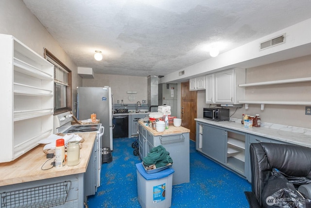 1927 SE Maple Dr, Chehalis, WA 98532 - kitchen with open shelves, stainless steel appliances, a textured ceiling, a center island, and white cabinets