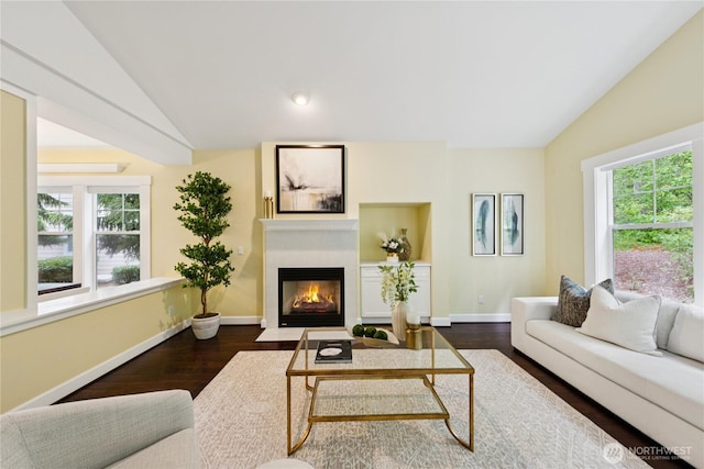 2218 Cascade Ct, Anacortes, WA 98221 - living room featuring lofted ceiling, plenty of natural light, wood finished floors, and a fireplace with flush hearth