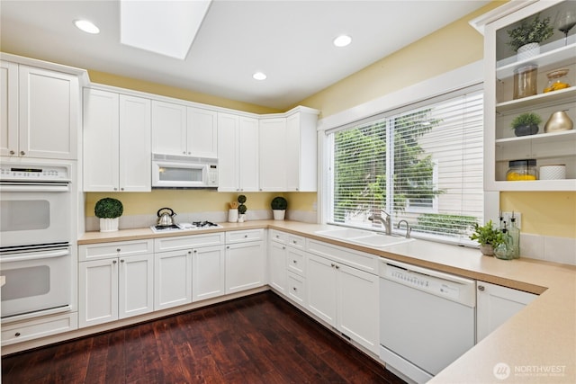 2218 Cascade Ct, Anacortes, WA 98221 - kitchen with white appliances, light countertops, white cabinetry, dark wood-type flooring, and a skylight