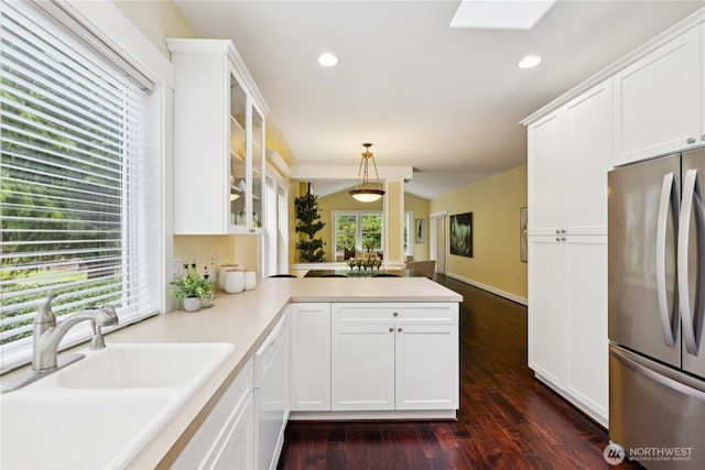 2218 Cascade Ct, Anacortes, WA 98221 - kitchen with freestanding refrigerator, white dishwasher, glass insert cabinets, a peninsula, and white cabinets