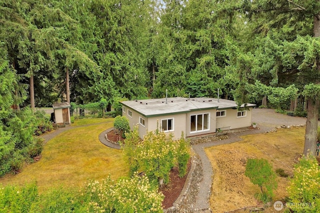 4210 Lakeway Dr, Bellingham, WA 98229 - rear view of house featuring dirt driveway, a storage unit, and a lawn