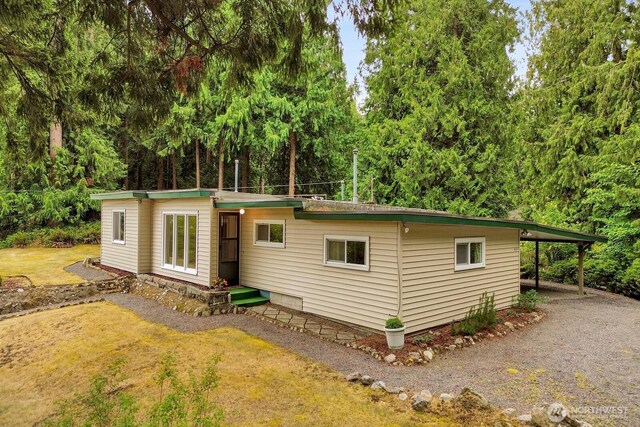 4210 Lakeway Dr, Bellingham, WA 98229 - view of front of home with a carport, a front yard, view of scattered trees, and driveway