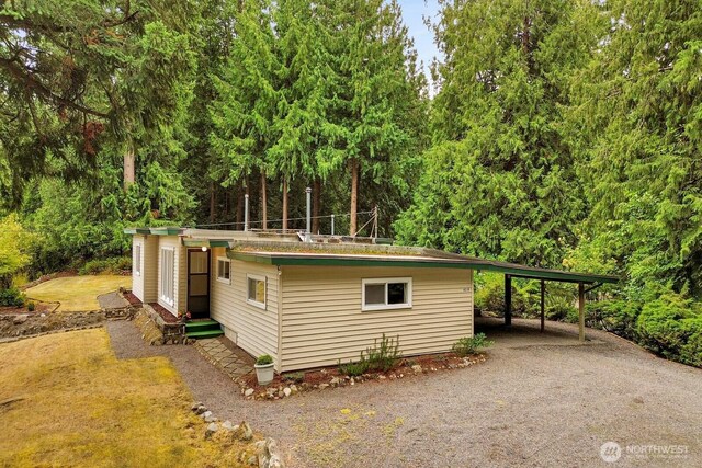 4210 Lakeway Dr, Bellingham, WA 98229 - view of outdoor structure featuring a carport, a forest view, and driveway