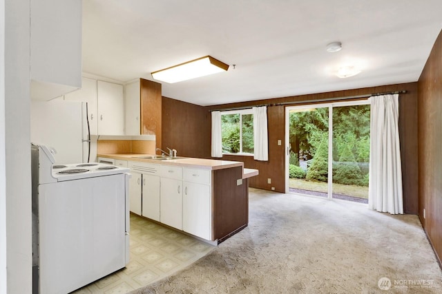 4210 Lakeway Dr, Bellingham, WA 98229 - kitchen with white appliances, a peninsula, light countertops, white cabinetry, and light flooring