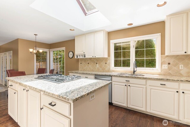 2444 220th Pl NE, Sammamish, WA 98074 - kitchen featuring appliances with stainless steel finishes, dark wood finished floors, a skylight, a center island, and light stone countertops