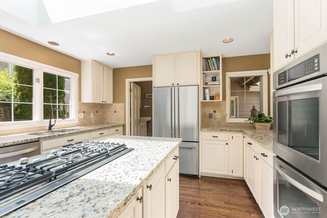 2444 220th Pl NE, Sammamish, WA 98074 - kitchen featuring stainless steel appliances, a skylight, backsplash, dark wood-type flooring, and recessed lighting